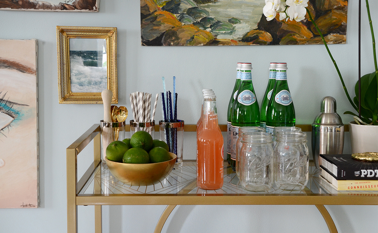 Bar cart with mason jars and straws for party drinks.